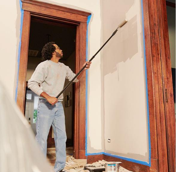 Professional painter painting an interior wall using a beige color.