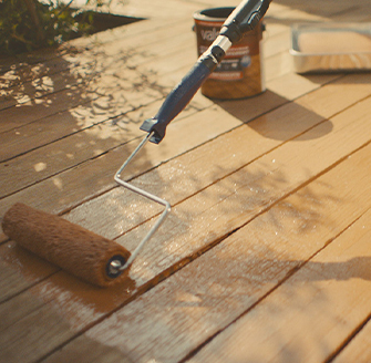 Roller painting with lighter neutral over a darker neutral and textured wall.