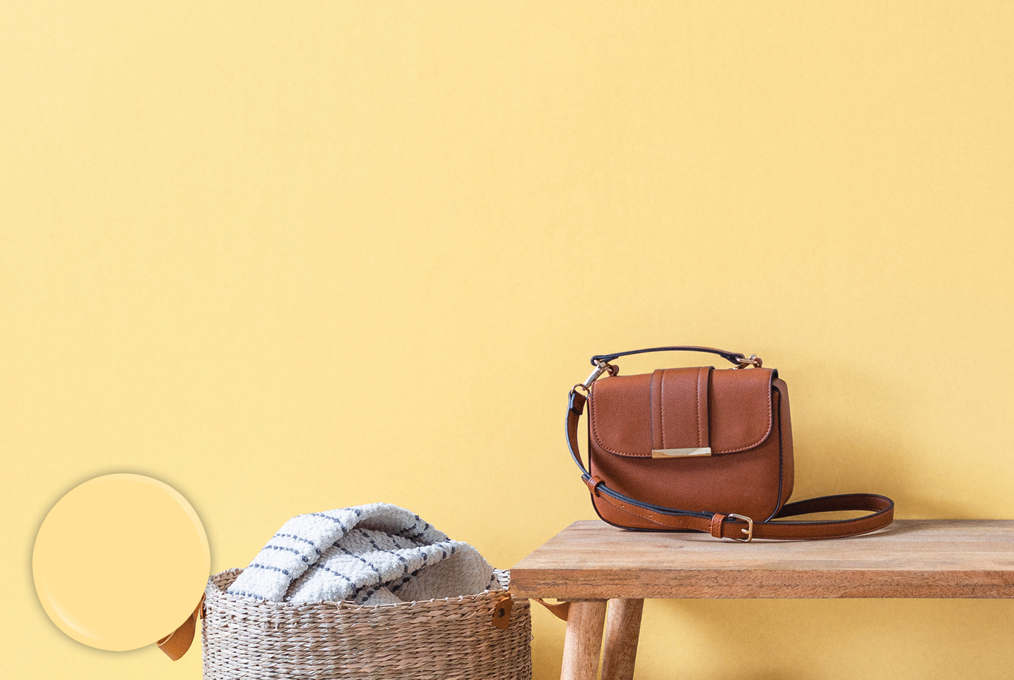 Entryway in Sunglow features a large woven basket and bench shoe bench upon which rests a leather purse. 