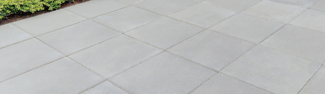 Concrete outdoor walkway or patio surface with squared sections.